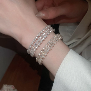 Macro view of multi-layer pearl bracelet with sparkling diamond-set spacers for women