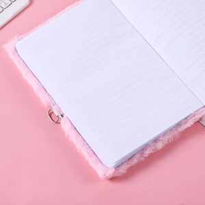 Pink plush notebook with heart lock and lined pages shown in a soft aesthetic close-up