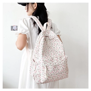 Girl wearing a Japanese style floral backpack with white and pink flower patterns