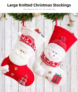 Große gestrickte Weihnachtssocken mit süßen Weihnachtsmann- und Schneemann-Motiven für Deko.