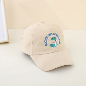 Dettaglio del ricamo a dinosauro e testo sulla calotta in cotone beige per bambini e neonati