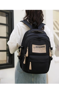 Detail of black school backpack featuring nylon fabric and adjustable side buckles