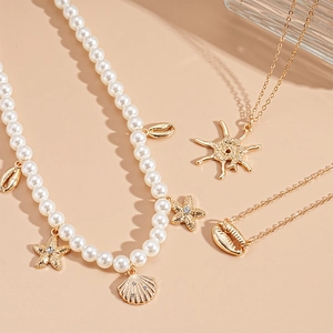 3-piece ocean theme jewelry set with pearls, starfish, and shells on beige background