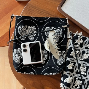 Retro black canvas crossbody bag featuring delicate white butterfly embroidery on wood