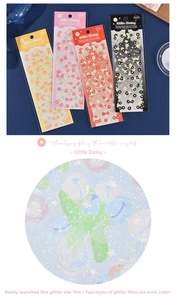 Macro detail of daisy stickers with sparkling star film effect on velvet background