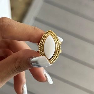 Macro view of vintage 18k gold ring with white marquise stone and twisted rope texture