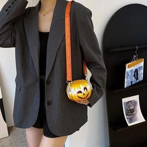 Detail of pumpkin-shaped crossbody bag with orange gradient and smiley face pattern