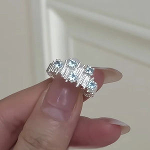 Detailed view of silver-toned irregular ring with five light blue zircon stones