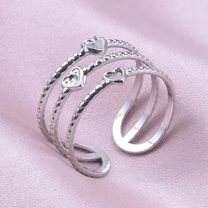 Detailed close-up of triple-layered silver heart rings with textured twisted rope band