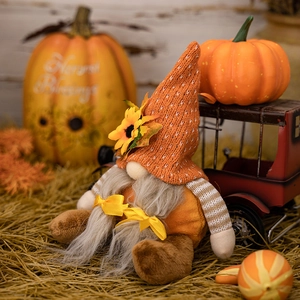 Detail of harvest gnome featuring sunflower knit hat and bows in autumn decor scene