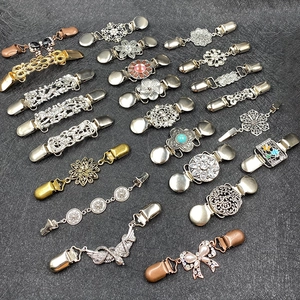 Macro shot of assorted vintage cardigan clips featuring rhinestones and faux pearls