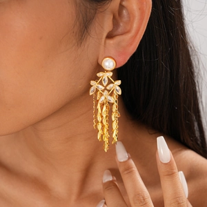 Detail of gold leaf tassel earrings with pearls and zircon flowers worn by a model