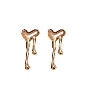 Polished gold metal heart earrings with a modern liquid lava drop design on white background