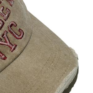 Dettaglio cappello baseball in velluto a coste kaki con ricamo NYC rosso e bordo