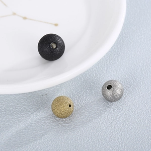 Close-up of matte stainless steel beads in black, gold and silver finishes for DIY jewelry