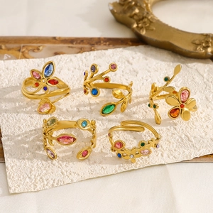 Macro shot of 18K gold leaf rings featuring various vibrant colorful zircon gemstones