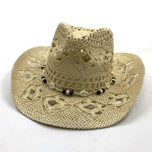Close-up of beige straw cowboy hat featuring ethnic beads and shell trim detail