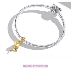 Detail of rose gold flower charm on a silver snake chain bracelet with crystal clasp