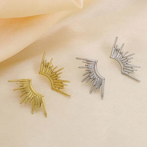 Starburst titanium steel earrings with 18k gold plating shown on beige satin background