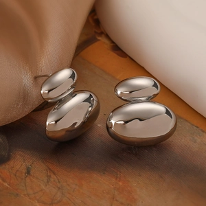 Minimalistische silberne geometrische Ohrstecker mit gestapeltem Oval-Design auf Textur