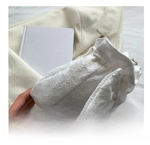 Close-up of white drawstring bag with detailed floral jacquard texture and embossed pattern