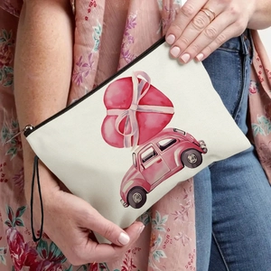 Cream canvas cosmetic bag with pink retro car and heart print held by a model