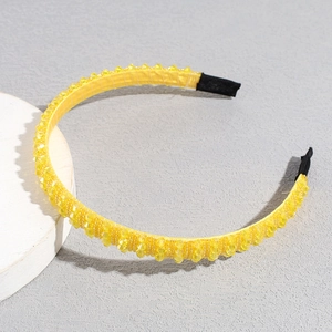 Detail of yellow beaded headband with faceted crystals and protective black ends