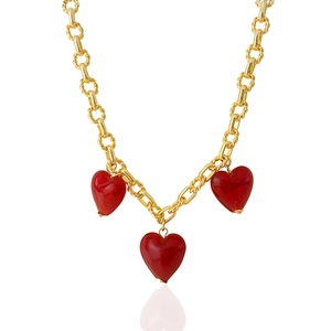 Close-up of chunky gold-plated chain featuring three glossy red Murano glass heart pendants
