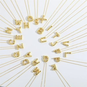 Golden letter necklace with inlaid white pearls arranged in a creative radial display