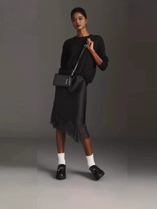 Elegant black crocodile-pattern shoulder bag paired with lace satin skirt and loafers