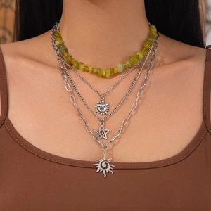 Détail d'un ensemble de 4 colliers argentés avec pendentifs soleil et perles vertes