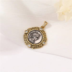 Detailed view of a vintage silver coin pendant with gold frame and inset crystals