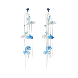 Detail of flower tassel earrings featuring blue floral motifs and silver chain fringe
