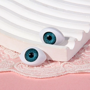 Macro shot of 14x19mm blue acrylic doll eyes with realistic iris texture on white stand