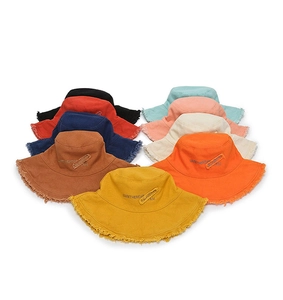 Flat lay of wide brim frayed edge bucket hats in multiple colors for summer sun protection