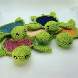 Close-up of handmade crochet turtle coasters with colorful knitted shell patterns