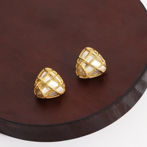 Macro detail of triangle stud earrings with twisted gold mesh and pearlescent inlay