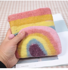 Detail view of handmade rainbow wool felt coin purse with cute pink pompom and zipper