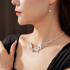 Detail showing shell necklace and matching earrings set on model for beach style