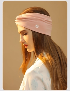 Pink twisted knot maternity headband with side logo for facial cleansing and sleeping