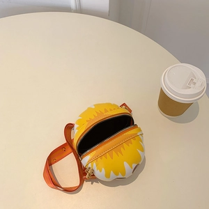 Detail shot of a round smiley crossbody bag with an open zipper and wide orange strap