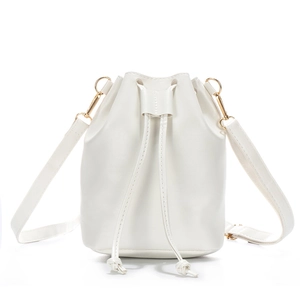 Minimalist white drawstring bucket bag with gold hardware and detachable shoulder strap