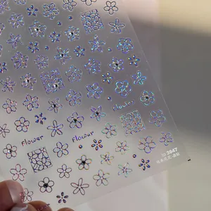 Détails macro de stickers ongles holographiques laser avec motifs de fleurs et cœurs brillants