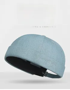 Detail of light blue denim docker hat with pink Masir Club embroidery and metal buckle