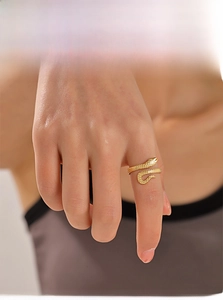 Detailed view of an adjustable golden snake ring with textured scales on a model finger