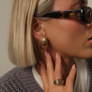 Close-up of vintage 18K gold-plated teardrop earrings and ring on a model
