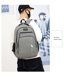 Rear view of a grey business backpack with multiple zipper compartments and black handles