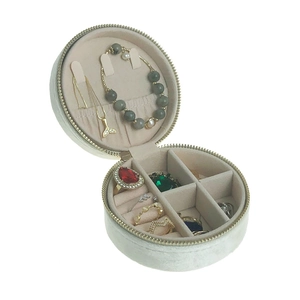 Internal layout of round beige velvet jewelry travel case with necklace hooks and ring slots
