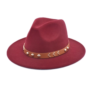Detail of wide brim wool fedora hat in wine red with brown leather studded band