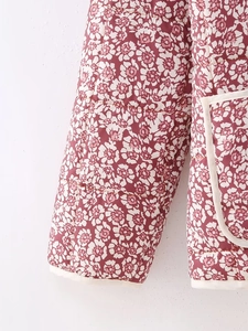 Detail of quilted floral jacket featuring cream trim on cuffs and side pocket